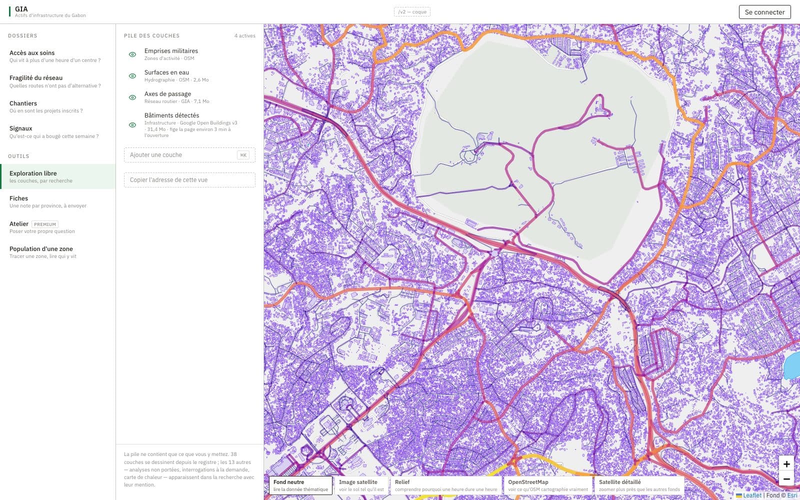 Libreville at street scale: detected building footprints in violet, through routes coloured by load, and a military zone outlined.